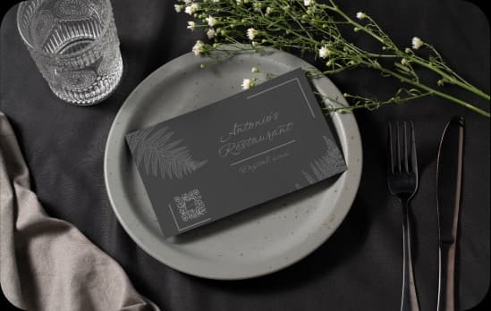 black leaflet on plates with a welcome to the restaurant and a QR code with the full menu
